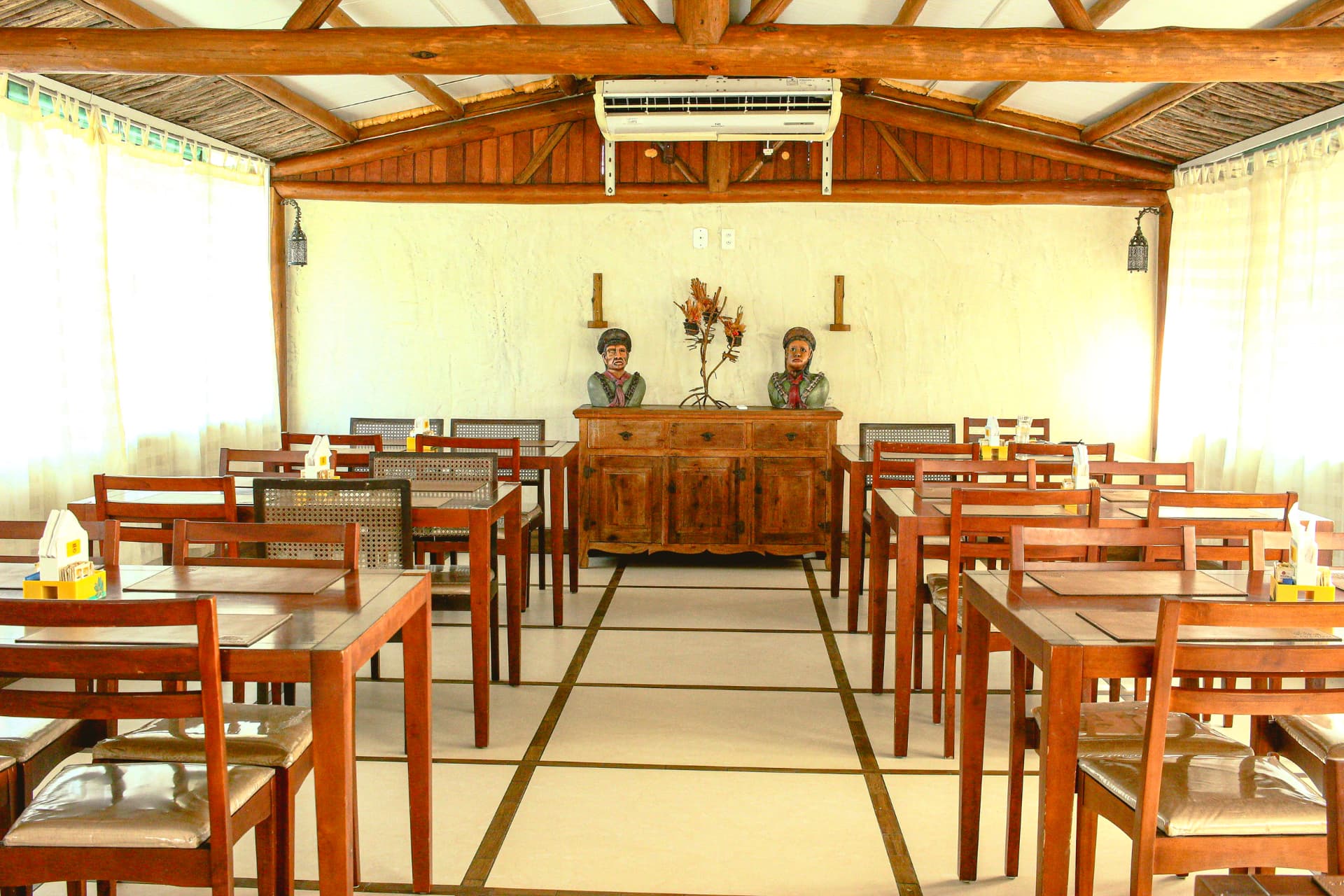 Ambiente interno do restaurante com decoração regional e mesas de madeira